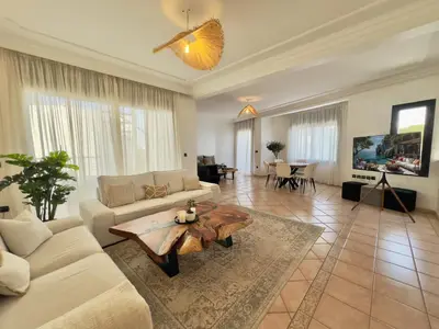 a living room with a couch and a table at Sunset escape by the sea in Temara