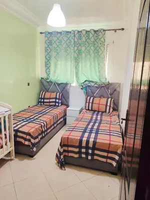 a bedroom with two beds and a window at Appartement propre et bien équipé à Ain sebaa in Casablanca