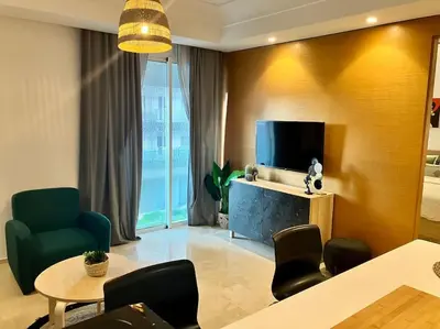 a living room with a tv and a table and chairs at Casablanca Appartement haut standing CFC in Casablanca