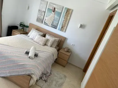 a bedroom with a bed with two pictures on the wall at Casablanca Appartement haut standing CFC in Casablanca