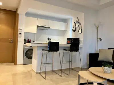 a kitchen with two bar stools in a living room at Casablanca Appartement haut standing CFC in Casablanca