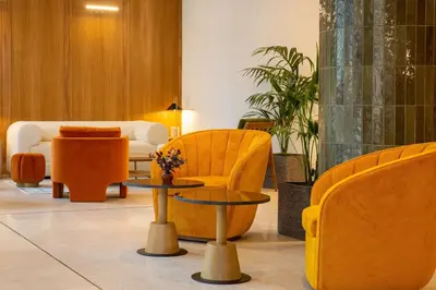 a lobby with yellow chairs and tables in a building at Best Western Plus Casablanca City Center in Casablanca