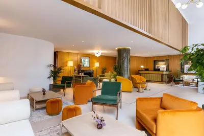 a lobby with orange and green chairs and tables at Best Western Plus Casablanca City Center in Casablanca