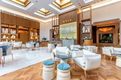 a lobby of a restaurant with white chairs and tables at Mazagan Beach & Golf Resort in El Jadida