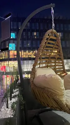 a wicker hammock hanging from a building at night at ZEN Suites Hotel Massira in Casablanca