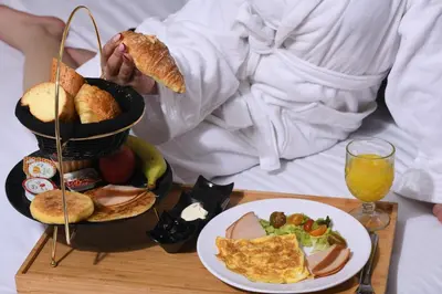 a person holding a tray with a plate of breakfast food at ZEN Suites Hotel Massira in Casablanca