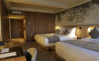 a hotel room with two beds and a table at Villa Blanca Urban Hotel in Casablanca