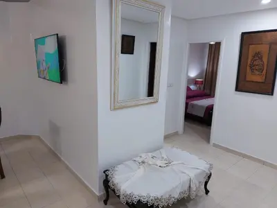 a white room with a bed and a mirror at harmony house 2 in Rabat