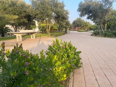 a park with a bench and some flowers and trees at Architects Haven in Luxury 3BR - Near Train & Tramway in Casablanca