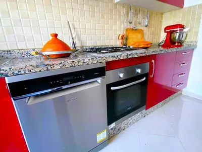 a kitchen with a stove and red cabinets at Architects Haven in Luxury 3BR - Near Train & Tramway in Casablanca