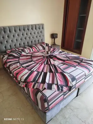 a large bed in a bedroom with a bedspread at appartement au bord de l'eau in Mohammedia