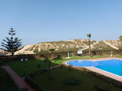 a swimming pool in a yard with a mountain in the background at appartement au bord de l'eau in Mohammedia