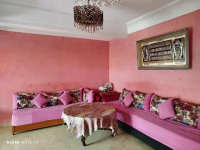 a pink living room with a pink couch and a table at appartement au bord de l'eau in Mohammedia