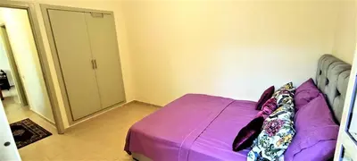 a bedroom with a purple bed and a closet at joli appartement près de la mer in Casablanca