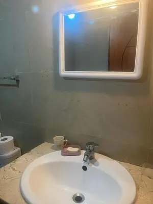 a bathroom with a white sink and a mirror at Appartement avec piscine proche de la plage in Mohammedia