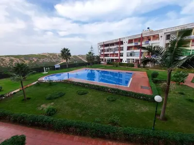 a large swimming pool in front of a building at Appartement avec piscine proche de la plage in Mohammedia