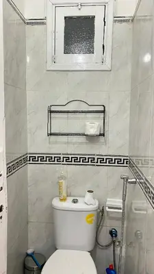a bathroom with a white toilet and a window at Housse F2 famille in Rabat