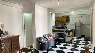 a kitchen with two chairs and a checkerboard floor at Housse F2 famille in Rabat