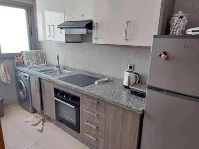 a kitchen with a refrigerator and a sink and a stove at BLANCA BEACH Sidi Rahal Front Mer in Sidi Rahal