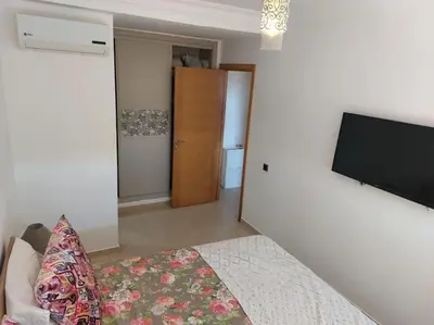 a bedroom with a bed and a flat screen tv at BLANCA BEACH Sidi Rahal Front Mer in Sidi Rahal